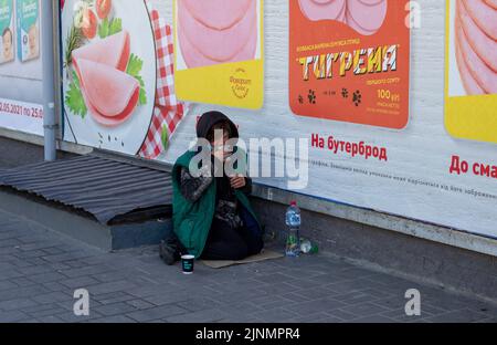 Novomoskovsk, Ukraine - 13. Mai 2021: Bettlerin auf der Straße, die um Geld bittet. Bettler. Soziale Probleme. Soziale Probleme Stockfoto