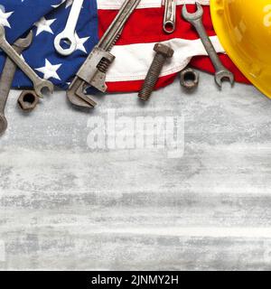 Labor Day oder American Labor Konzept mit Bau-und Fertigungs-Tools auf patriotischen US, USA, amerikanische Flagge auf weißem Holzhintergrund Stockfoto