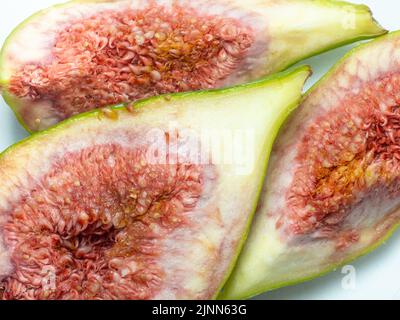 Stücke von gehackten grünen Feigen. Saftige reife Früchte. Diät-Essen. Abb. isolieren. Samen innen schneiden Früchte Stockfoto