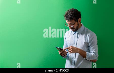 Isolierte Person, die sein Handy überprüft, Jugendlicher, der sein Handy isoliert überprüft, Blick auf einen gutaussehenden Mann, der ein isoliertes Handy verwendet Stockfoto