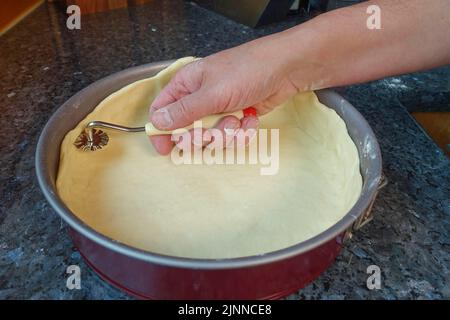 Schwäbische Küche, Zubereitung von Haertsfelder Kartoffelkuchen, Quark mit Teigrad schneiden, Backblech, Kuchenform, Frühlingsform, herzhafter Kuchen, Backen Stockfoto