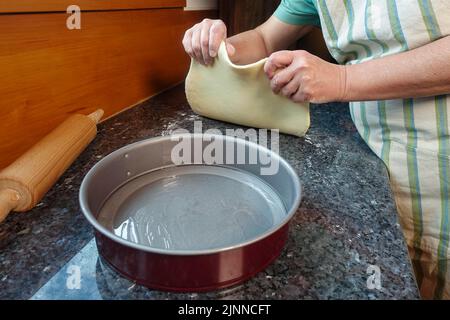 Schwäbische Küche, Zubereitung von Haertsfelder Kartoffelkuchen, Quark in Backform geben, Springform, Kuchenblech, Nudelholz, herzhafter Kuchen, Backen Stockfoto