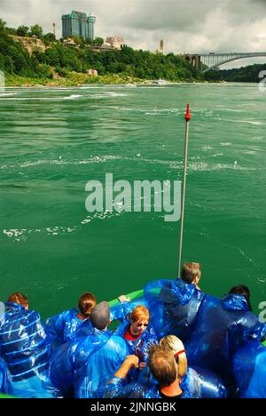 Eine nasse Gruppe von Passagieren kehrt von einem Nahbesuch mit den Horseshoe Falls in den Niagarafällen zurück, während sie an Bord des „Maid of the Mist“-Ausflugsboots sind Stockfoto