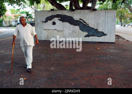 Ein älterer Mann geht in einem Park im Viertel Calle Ocho Little Havana in Miami, wo viele Menschen kubanischer Abstammung leben, am Denkmal für Kuba vorbei Stockfoto