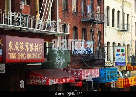 Unternehmen in San Franciscos Chinatown hängen ihre Schilder in zwei Sprachen, um die Anwohner und die Touristen anzuziehen Stockfoto