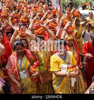 Neu Delhi, Indien April 03 2022 - Frauen mit Kalash am Kopf während des Jagannath-Tempels Mangal Kalash Yatra tragen indische Hindu-Anhänger irdische Töpfe Conta Stockfoto