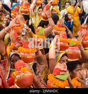 Neu Delhi, Indien April 03 2022 - Frauen mit Kalash am Kopf während des Jagannath-Tempels Mangal Kalash Yatra tragen indische Hindu-Anhänger irdische Töpfe Conta Stockfoto