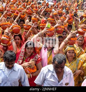 Neu Delhi, Indien April 03 2022 - Frauen mit Kalash am Kopf während des Jagannath-Tempels Mangal Kalash Yatra tragen indische Hindu-Anhänger irdische Töpfe Conta Stockfoto