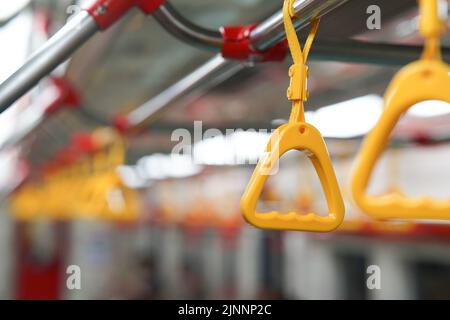 Selektiver Fokus auf gelb hängenden Griff Griff auf öffentlichen Verkehrsmitteln wie Bus und Bahn kann Quelle für Virusinfektion und Gesundheitsprobleme sein. Stockfoto