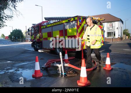Slough, berkshire, Großbritannien. 13.. August 2022. Ein Löschmotor bezieht Wasser aus einem Hydranten. Royal Berkshire Fire and Rescue Service lösten heute Morgen ein Feuer in der Simpson Recycling-Anlage in Simpsons Way, Slough, hinter dem Ramgarhia Sikh Tempel. Den Anwohnern wurde geraten, drinnen zu bleiben und ihre Fenster geschlossen zu halten. Ein Zetros Feuerwehrwagen, der 8.000 Liter Wasser fasst, war ebenfalls vor Ort, um das Feuer zu dämpfen. Quelle: Maureen McLean/Alamy Live News Stockfoto