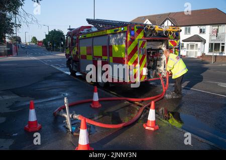 Slough, berkshire, Großbritannien. 13.. August 2022. Ein Löschmotor bezieht Wasser aus einem Hydranten. Royal Berkshire Fire and Rescue Service lösten heute Morgen ein Feuer in der Simpson Recycling-Anlage in Simpsons Way, Slough, hinter dem Ramgarhia Sikh Tempel. Den Anwohnern wurde geraten, drinnen zu bleiben und ihre Fenster geschlossen zu halten. Ein Zetros Feuerwehrwagen, der 8.000 Liter Wasser fasst, war ebenfalls vor Ort, um das Feuer zu dämpfen. Quelle: Maureen McLean/Alamy Live News Stockfoto