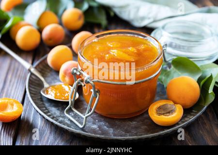 Hausgemachte Konservierung. Köstliche Aprikosenmarmelade oder Gelee auf einem rustikalen Holztisch. Stockfoto