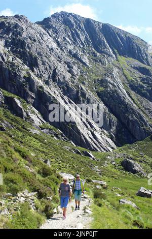 Zwei Senior Walkers Auf Dem Weg Um Llyn Idwal, Die Berühmten Idwal Platten Im Hintergrund Stockfoto