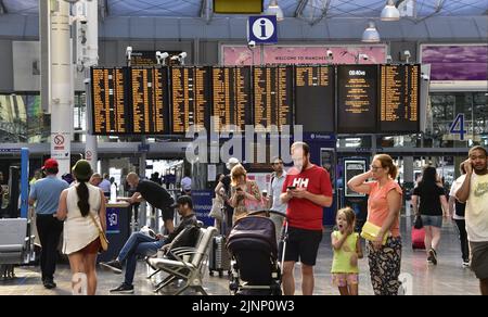 Manchester, Großbritannien, 13.. August 2022. Informationstafeln und Fahrgäste zu den Zugzeiten am Bahnhof Piccadilly, Manchester, Großbritannien. Der Streik wird von ASLEF, der Gewerkschaft der Zugführer, organisiert und umfasst die Zugführer von neun Eisenbahnunternehmen: London Overground, Avanti West Coast, Crosscountry, Southeastern, Greater Anglia, Great Western Railway, Hull Trains, LNER, West Midlands Trains. ASLEF sagt, dass diese Unternehmen „kein Lohnangebot gemacht haben“ und „die Fahrer dieser neun Unternehmen seit drei Jahren keinen Anstieg mehr hatten“. Quelle: Terry Waller/Alamy Live News Stockfoto