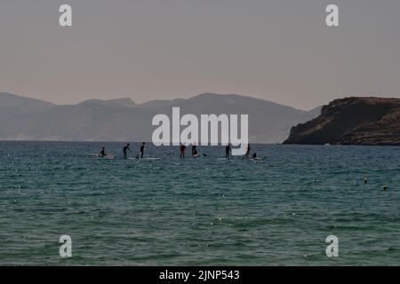 IOS, Griechenland - 8. Juni 2021 : Junge Touristen genießen Stand-up-Paddle-Boarding am berühmten Strand von Mylopotas iOS Greece Stockfoto