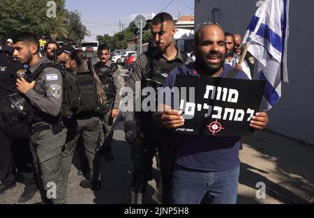 Ein rechter Gegenprotzer hält ein Schild mit der Aufschrift „Tod den Terroristen“, als er israelische linke Aktivisten und Palästinenser konfrontiert, die am 12. August 2022 in Jerusalem, Israel, an einer Demonstration gegen israelische Besatzung und Siedlungsaktivitäten im Stadtteil Sheikh Jarrah teilnehmen. Das palästinensische Viertel Sheikh Jarrah ist derzeit das Zentrum einer Reihe von Eigentumsstreitigkeiten zwischen Palästinensern und rechtsgerichteten jüdischen Israelis. Einige Häuser wurden nach einem Gerichtsurteil von israelischen Siedlern besetzt Stockfoto