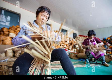 Jinan, Chinas Provinz Shandong. 2. August 2022. Dorfbewohner weben Strohhandwerk in der Gemeinde Damatou der Stadt Dongying, ostchinesische Provinz Shandong, 2. August 2022. Quelle: Xu Suhui/Xinhua/Alamy Live News Stockfoto