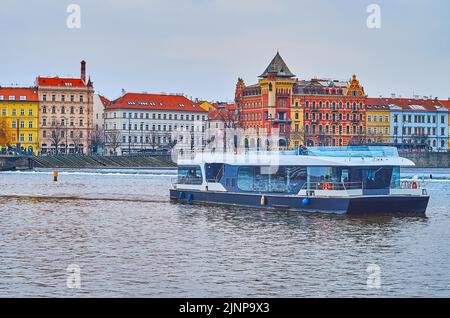 Der Blick auf die Moldau mit dem modernen Touristenschiff und die Reihe der historischen Häuser mit Bellevue-Villa im Hintergrund, Prag, Tschechische Republik Stockfoto
