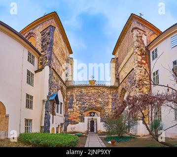 Die Steinmauer mit Glockentürmen des historischen Johanniter-Klosters und des Maltesischen Rittergartens im Vordergrund, Prag, Tschechische Republik Stockfoto