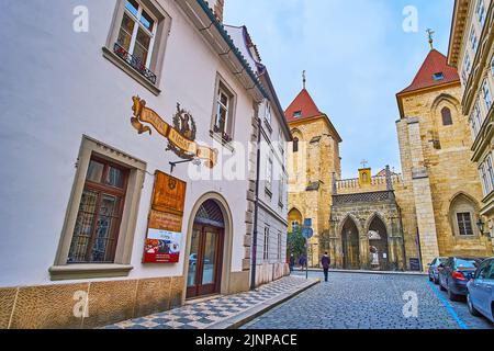 PRAG, TSCHECHISCHE REPUBLIK - 6. MÄRZ 2022: Lazenska Straße auf der Kleinseite öffnet den Blick auf das mittelalterliche Tor und die Glockentürme des Johanniter-Klosters, Stockfoto