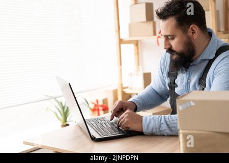 Indische Unternehmer Kleinunternehmen KMU unabhängige Männer arbeiten zu Hause verwenden Laptops für kommerzielle Überprüfung, Online-Marketing, Verpackung Boxen, KMU-Verkäufer Stockfoto