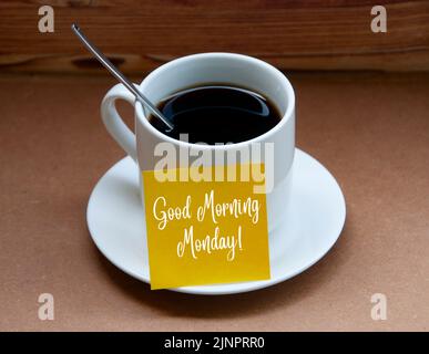 Morgengrüße Text auf gelbem Notizblock auf Kaffeetasse - Guten Morgen Montag. Stockfoto