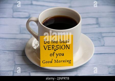 Inspirierender Zitat-Text auf gelbem Notizblock auf Kaffeetasse – sei die beste Version von dir. Grußwort-Konzept. Stockfoto