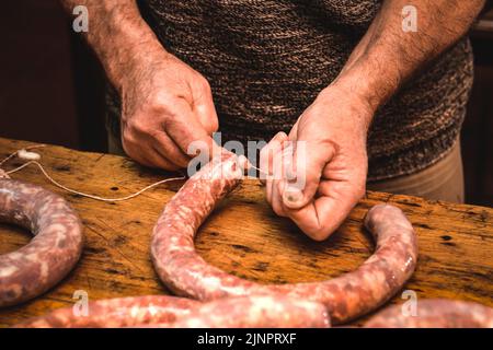 Hände arbeiten an der Herstellung von Würsten, traditionelle argentinische Schlachtung. Stockfoto