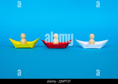 Puppenfiguren auf gelbem, rotem und weißem Schiff. Raum und Partnerschaftskonzept kopieren. Stockfoto