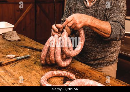 Hände arbeiten an der Herstellung von Würsten, traditionelle argentinische Schlachtung. Stockfoto