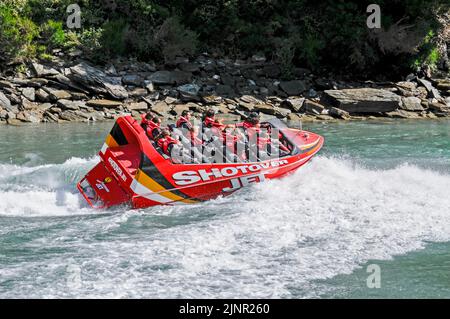 Die Besucher genießen den Nervenkitzel mit hoher Geschwindigkeit auf einem Shotover-Jet-Flachbodenboot, das mit zwei 350 Mercruiser V8-Motoren angetrieben wird und ein kombiniertes 700-Pferd produziert Stockfoto
