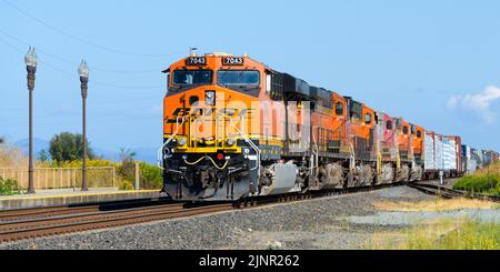 Stanwood, WA, USA - 11. August 2022; BNSF gemischter Güterzug mit sechs Triebwerken in Stanwood Washington unter blauem Himmel Stockfoto