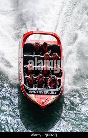Die Besucher genießen den Nervenkitzel mit hoher Geschwindigkeit auf einem Shotover-Jet-Flachbodenboot, das mit zwei 350 Mercruiser V8-Motoren angetrieben wird und ein kombiniertes 700-Pferd produziert Stockfoto