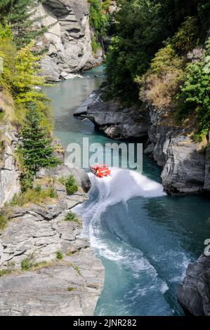 Die Besucher genießen den Nervenkitzel mit hoher Geschwindigkeit auf einem Shotover-Jet-Flachbodenboot, das mit zwei 350 Mercruiser V8-Motoren angetrieben wird und ein kombiniertes 700-Pferd produziert Stockfoto