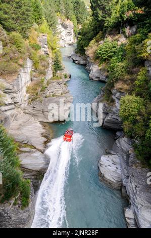 Die Besucher genießen den Nervenkitzel mit hoher Geschwindigkeit auf einem Shotover-Jet-Flachbodenboot, das mit zwei 350 Mercruiser V8-Motoren angetrieben wird und ein kombiniertes 700-Pferd produziert Stockfoto