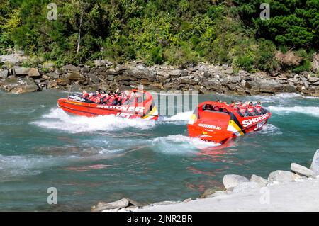 Die Besucher genießen den Nervenkitzel mit hoher Geschwindigkeit auf einem Shotover-Jet-Flachbodenboot, das mit zwei 350 Mercruiser V8-Motoren angetrieben wird und ein kombiniertes 700-Pferd produziert Stockfoto