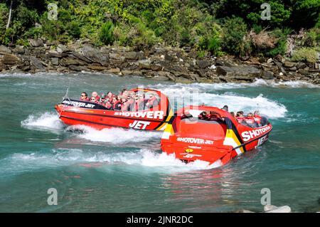 Besucher genießen den Nervenkitzel mit hoher Geschwindigkeit auf einem Shotover Jet-Flachbodenboot, das mit zwei 350 Mercruiser V8-Motoren angetrieben wird und ein kombiniertes 700-Pferd produziert Stockfoto