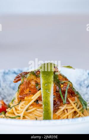 Spaghetti mit einer würzigen Sauce, Chili, Pfeffer und geriebenem Parmesan Stockfoto