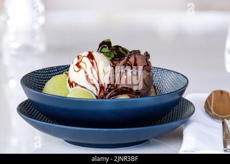 Fruchteis auf Melonenbällen auf Marmortisch Stockfoto