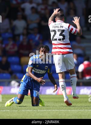 Wimbledons Paris Maghoma wird während des zweiten Spiels der Sky Bet League im Cherry Red Records Stadium, London, von Doncasters Lee Tomlin angestickt. Bilddatum: Samstag, 13. August 2022. Stockfoto