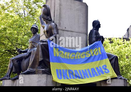 Manchester, Großbritannien, 13.. August 2022. Ein „Manchester Ukrainians“-Banner auf den Bronzefiguren auf der Statue des Herzogs von Wellington. „Manchester steht mit der Ukraine“, eine Anti-Kriegs-Kundgebung, ein Protest gegen die russische Invasion der Ukraine, in Piccadilly Gardens, im Zentrum von Manchester, England, Vereinigtes Königreich. Die Proteste werden vom Ukrainischen Kulturzentrum, Manchester, organisiert. An diesem Samstag, dem 25.., wurde dieser Protest abgehalten, um die Aufmerksamkeit auf den anhaltenden Krieg zu lenken und um Unterstützung für die Ukraine zu suchen. Quelle: Terry Waller/Alamy Live News Stockfoto