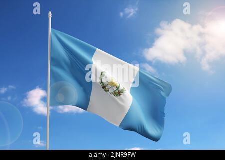 Flagge Guatemalas am blauen Himmel. 3D Abbildung. Stockfoto