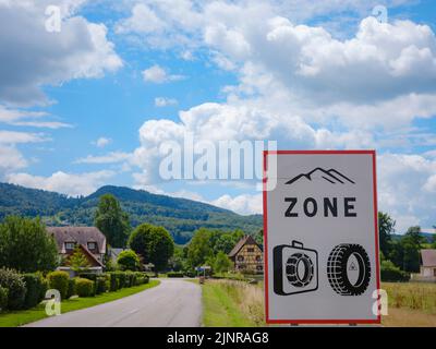 oad-Schild mit Aufschrift in deutscher Sprache, das heißt, Winterreifen oder Schneeketten sind von November bis April an Bord Pflicht. Stockfoto