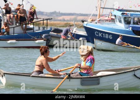 West Mersea, Großbritannien. 13. August 2022. Die West Mersea Regatta findet auf Mersea Island statt. Die Regatta wird seit 1838 fast ununterbrochen durchgeführt und wird von Freiwilligen organisiert. Die Augenbinde Rennen mit Dame coxswains. Kredit: Eastern Views/Alamy Live Nachrichten Stockfoto