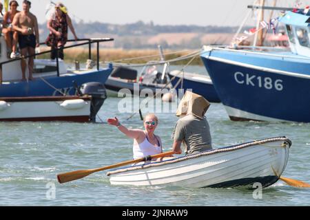 West Mersea, Großbritannien. 13. August 2022. Die West Mersea Regatta findet auf Mersea Island statt. Die Regatta wird seit 1838 fast ununterbrochen durchgeführt und wird von Freiwilligen organisiert. Die Augenbinde Rennen mit Dame coxswains. Kredit: Eastern Views/Alamy Live Nachrichten Stockfoto