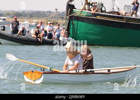 West Mersea, Großbritannien. 13. August 2022. Die West Mersea Regatta findet auf Mersea Island statt. Die Regatta wird seit 1838 fast ununterbrochen durchgeführt und wird von Freiwilligen organisiert. Die Augenbinde Rennen mit Dame coxswains. Kredit: Eastern Views/Alamy Live Nachrichten Stockfoto