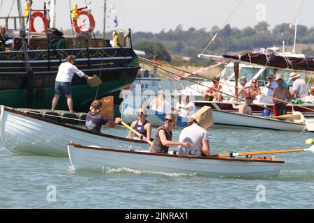 West Mersea, Großbritannien. 13. August 2022. Die West Mersea Regatta findet auf Mersea Island statt. Die Regatta wird seit 1838 fast ununterbrochen durchgeführt und wird von Freiwilligen organisiert. Die Augenbinde Rennen mit Dame coxswains. Kredit: Eastern Views/Alamy Live Nachrichten Stockfoto