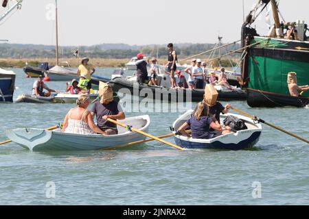 West Mersea, Großbritannien. 13. August 2022. Die West Mersea Regatta findet auf Mersea Island statt. Die Regatta wird seit 1838 fast ununterbrochen durchgeführt und wird von Freiwilligen organisiert. Die Augenbinde Rennen mit Dame coxswains. Kredit: Eastern Views/Alamy Live Nachrichten Stockfoto