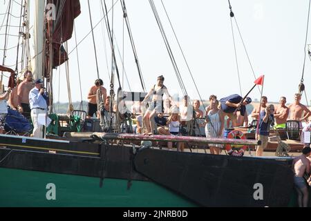 West Mersea, Großbritannien. 13. August 2022. Die West Mersea Regatta findet auf Mersea Island statt. Die Regatta wird seit 1838 fast ununterbrochen durchgeführt und wird von Freiwilligen organisiert. Auf dem fettigen Pfahl gehen. Kredit: Eastern Views/Alamy Live Nachrichten Stockfoto