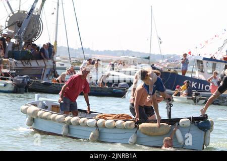 West Mersea, Großbritannien. 13. August 2022. Die West Mersea Regatta findet auf Mersea Island statt. Die Regatta wird seit 1838 fast ununterbrochen durchgeführt und wird von Freiwilligen organisiert. Schwimmer, die ins Wasser tauchen, sind bereit für den Start des Schwimmrennens. Kredit: Eastern Views/Alamy Live Nachrichten Stockfoto